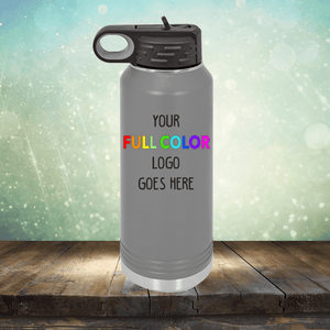 Gray Custom UV Printed Drinkware - Single Side Printing Included in Price from Kodiak Coolers with a black lid and a space for a full-color logo with the text "YOUR FULL COLOR LOGO GOES HERE" on a wooden surface against a blurred background. Perfect next to your personalized coffee mugs or customized tumblers.