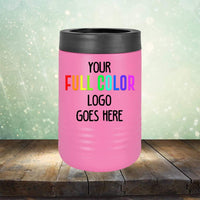A pink insulated can cooler with a black top and the text "YOUR FULL COLOR LOGO GOES HERE." The background is a wooden surface with a green and white gradient, bokeh effect. Perfect for pairing with Custom UV Printed Drinkware - Single Side Printing Included in Price by Kodiak Coolers or personalized coffee mugs.