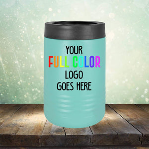 A blue Kodiak Coolers Custom UV Printed Drinkware - Single Side Printing Included in Price with a black top sits on a wooden surface. The text on the cooler reads "YOUR FULL COLOR LOGO GOES HERE." Surrounding the cooler is a light, bokeh effect that gives the scene an elegant touch, perfect for showcasing personalized coffee mugs or engraved wine cups alongside it.