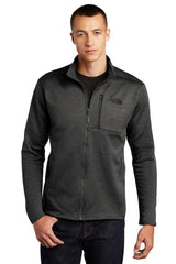 Man wearing a dark grey The North Face NF0A47F5 Full-Zip Fleece Jacket made of recycled polyester and jeans.