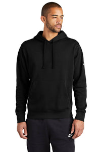 A person dressed in a Nike Club Fleece Sleeve Swoosh Pullover Hoodie Sweatshirt NKDR1499 and black pants, embodying a casual street-ready look, stands against a white background.