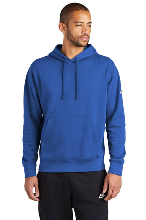 A person wearing a Nike Club Fleece Sleeve Swoosh Pullover Hoodie Sweatshirt (NKDR1499) in blue and black pants stands against a plain white background, perfectly capturing a casual street-ready look.