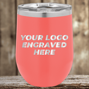 A pink insulated tumbler by Kodiak Coolers, engraved with your custom company logo, perfect as a realtor closing gift for clients. Features a clear lid and is ideal promotional drinkware, shown on wood with a blurred background.