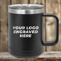 A black 15 oz Kodiak Coolers insulated mug with a silver lid sits elegantly on wood, featuring "YOUR LOGO ENGRAVED HERE" in white. Ideal for custom mugs or promotional gifts, each purchase includes a logo engraving and setup fee.