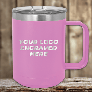On a wooden surface sits the pink 15 oz insulated coffee mug by Kodiak Coolers, ideal for promotional gifts. With "YOUR LOGO ENGRAVED HERE," it shows how brands can have personalized mugs, including an engraved logo sample and setup fee.