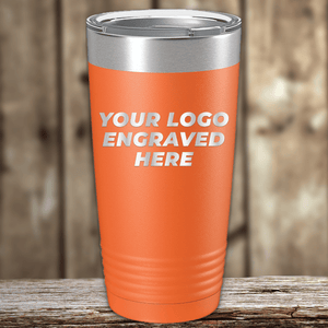 An orange Kodiak Coolers tumbler with a metallic lid rests on wood, featuring "YOUR LOGO ENGRAVED HERE." This Realtor Closing Gift lets you add your custom company logo—an ideal promotional item or personalized drinkware keepsake.
