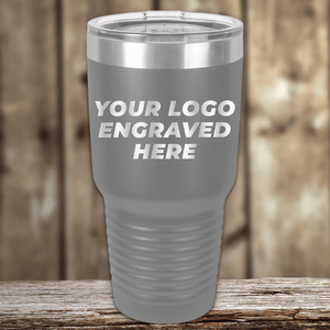 Showcased is the Kodiak Coolers SAMPLE - 30 oz Tumbler, gray with a clear lid and custom engraved logo—ideal for branded promotional drinkware; price includes logo engraving sample and volume setup fee.
