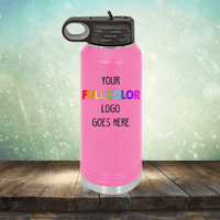 Pink water bottle with a black lid and handle, displayed on a wooden surface against a blurred background. The text on the bottle reads, "Your Full Color Logo Goes Here." Perfect for coffee mugs or tumblers, this item can also feature custom engraving for a personalized touch. Introducing the Custom UV Printed Drinkware - ONE TIME SPECIAL OFFER by Kodiak Coolers.