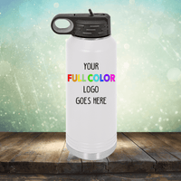 A white reusable water bottle with a black lid is displayed with the text "Your Full Color Logo Goes Here" printed on its front. The background features a blurred, light-filled design. Perfect for pairing with our customizable coffee mugs and tumblers, the Kodiak Coolers Custom UV Printed Drinkware - ONE TIME SPECIAL OFFER can also feature precise engraving for added elegance.