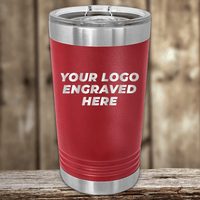The Kodiak Coolers Realtor Closing Gifts for Clients tumbler features your custom company logo engraved in white on red insulated drinkware with a clear lid—ideal for personalized or custom logo mugs, displayed on a wooden surface.