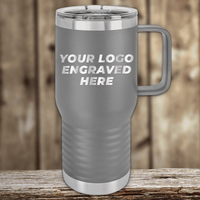 Gray insulated travel mug by Kodiak Coolers with a handle and clear plastic lid, featuring your custom company logo—ideal as Realtor closing gifts or promotional drinkware—displayed on wood with a “YOUR LOGO ENGRAVED HERE” design.