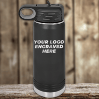 A black Kodiak Coolers bottle sits on a wooden surface, featuring "YOUR LOGO ENGRAVED HERE," making it a stylish Realtor Closing Gift for clients with your custom company logo on drinkware against a blurred wood background.