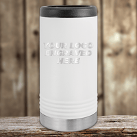 White insulated tumbler by Kodiak Coolers with black lid and metallic base, featuring "YOUR LOGO ENGRAVED HERE"—the perfect Realtor closing gift. Showcase your custom company logo on this personalized drinkware for clients. Blurred wooden background.