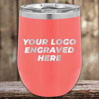 A coral-pink Kodiak Coolers insulated tumbler with a customizable engraving area for an engraved logo, displayed on a wooden surface.