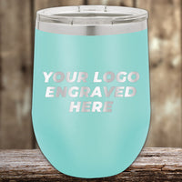 Aqua-colored Kodiak Coolers custom stemless wine cup with a customizable engraved logo area, displayed on a wooden surface.
