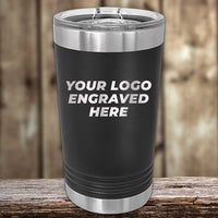 A black, stainless steel Kodiak Coolers Custom Pint Tumbler with customizable engraving on a wooden surface.