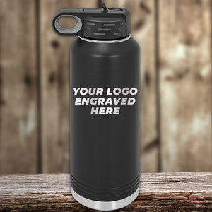A black Kodiak Coolers insulated bottle rests on wood, engraved with "YOUR LOGO HERE." The logo pops on its sleek design. The blurred background enhances this perfect custom tumbler, available at wholesale prices. Special Presidents Day Sale: No setup fee, $250 order minimum includes 1-side logo.