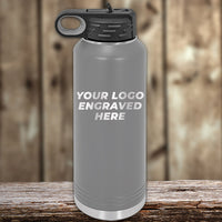 A personalized silver insulated bottle with a black lid displays "YOUR LOGO ENGRAVED HERE" against a wooden backdrop. Kodiak Coolers offers this sleek option with laser-engraved logos for $250 minimum during the Presidents Day sale, no setup fee, and one side logo included.