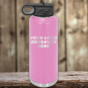 A pink engraved Custom Water Bottles 40 oz with your Logo or Design Engraved on a wooden surface by Kodiak Coolers.