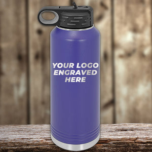 A Kodiak Coolers purple water bottle with an engravable logo area displayed on a wooden surface.