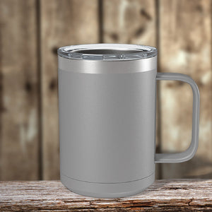 A gray insulated mug with a Kodiak Coolers custom logo sitting on a wooden table.