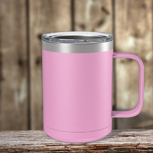 A Kodiak Coolers pink insulated coffee mug resting on a wooden table, perfect for staying warm on chilly days.