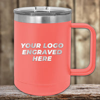 A coral-colored Kodiak Coolers mug with a metal lid rests on wood. "YOUR LOGO ENGRAVED HERE" promotes Engraved Custom Logo Drinkware—single side engraving included, bulk pricing available—ideal for custom brand or event mugs.