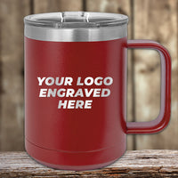 A Kodiak Coolers Custom Coffee Mug, 15 oz, with your logo or design engraved, shown in red with silver lid and handle. Special Black Friday Sale and volume pricing—LIMITED TIME. Mug displayed on wood with a blurred wooden background.