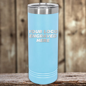 A blue Custom Skinny Tumbler 22 oz with your Logo or Design engraved on its surface, displayed on a wooden surface with a blurred background, is perfect as engraved drinkware for promotional materials from Kodiak Coolers.