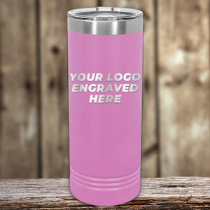 A pink insulated Custom Skinny Tumbler 22 oz by Kodiak Coolers, perfect as promotional materials, with "your logo engraved here" text showcased on a wooden surface.