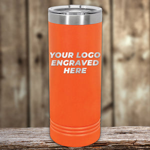 Orange insulated Kodiak Coolers custom skinny tumbler with engraved drinkware space displayed on a wooden surface.
