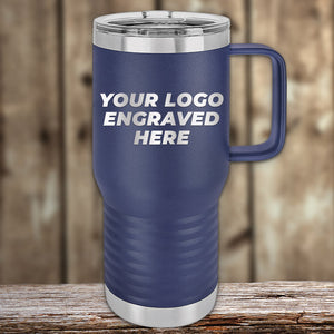 A blue insulated travel mug by Kodiak Coolers, featuring the text "Your Logo Engraved Here," sits on a wooden surface with a blurred wooden background. Perfect for custom tumblers with laser-engraved logos, available at wholesale prices from Custom Engraved Drinkware—no setup fee and $250 minimum order required.