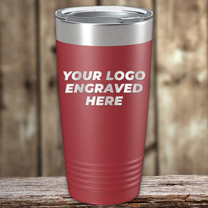 A red Kodiak Coolers Engraved Custom Logo Drinkware tumbler with a metal lid sits on wood, featuring "YOUR LOGO ENGRAVED HERE"—ideal for branded, personalized mugs. Single side engraving and bulk tiered pricing included.