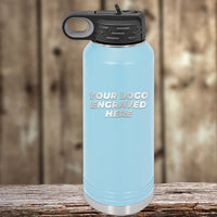 A light blue Kodiak Coolers water bottle with a black lid and handle, featuring your custom logo engraved on one side—single side engraving included in price—makes a great set with custom mugs; shown on a wooden background.