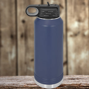 A Kodiak Coolers blue insulated stainless steel water bottle with a built-in drinking spout, resting on a wooden surface against a blurred wooden background.