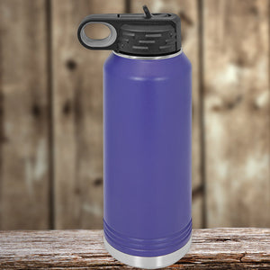 A purple insulated stainless steel Kodiak Coolers water bottle with a black cap, placed on a wooden surface against a blurred wooden background.
