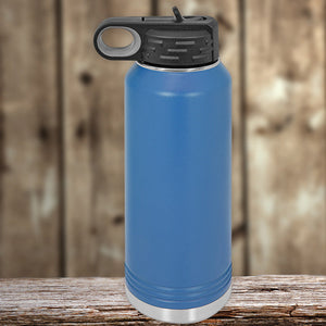 Custom Kodiak Coolers 32 oz insulated stainless steel water bottle with a black lid, placed on a wooden surface against a blurred wooden background.