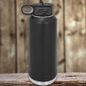 Black insulated stainless steel Custom Water Bottles 40 oz with your Logo or Design Engraved from Kodiak Coolers on a wooden surface with a blurred background.