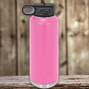 Pink Kodiak Coolers insulated stainless steel water bottle on a wooden surface.