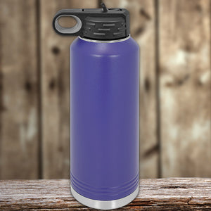 A blue insulated stainless steel Custom Water Bottles 40 oz with your Logo or Design Engraved, with a black lid, placed on a wooden surface against a blurred background. Brand Name: Kodiak Coolers