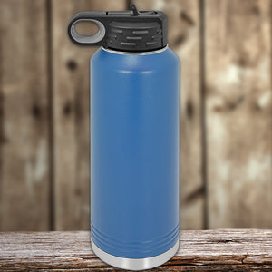 Blue insulated stainless steel Kodiak Coolers water bottle on a wooden surface.