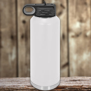 White Kodiak Coolers water bottle with a custom logo laser engraved, and a black flip lid on a wooden surface against a blurred wooden background.