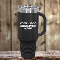 Kodiak Coolers' custom engraved travel mug features a black design with a silver lid and straw, laser-etched with "YOUR LOGO ENGRAVED HERE." Ideal for unique tastes at wholesale prices, it's shown on a wooden surface with a rustic backdrop. $250 minimum order for this special sale.
