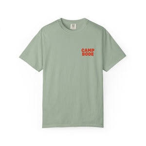 The BODE Summer Camp T-Shirt 2026 — "Throwback Sunset" by Printify is a light green, garment-dyed unisex tee with bold red "CAMP BODE" on the left chest. Enjoy comfort and style, perfect for any camp adventure.