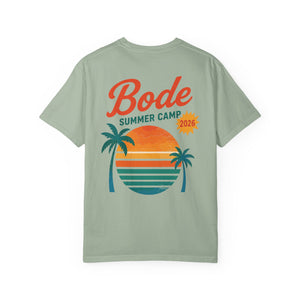 The BODE Summer Camp T-Shirt 2026 — "Throwback Sunset" by Printify is a light green unisex Comfort Colors 1717 tee with “Bode Summer Camp 2026” and a sunset, ocean, and palm trees graphic for relaxed summer style.