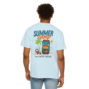 A person wears the BODE Summer Camp T-Shirt 2026 by Printify, a light blue unisex heavyweight cotton tee featuring palm trees, a cooler, hat, and "SUMMER camp" plus "Life's Better Together" on the back.