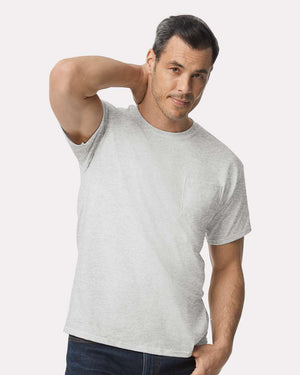 A man wears a light gray Gildan 2300 Unisex Ultra Cotton® Pocket T-Shirt with a custom screen printed logo and dark jeans, standing against a plain white background.