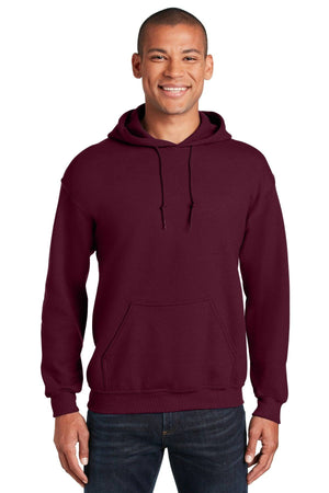 A person models a plain maroon Gildan Heavy Blend™ Hooded Sweatshirt (Pack of 36, style 18500) with custom screen printed logo and dark jeans, smiling at the camera against a white background.
