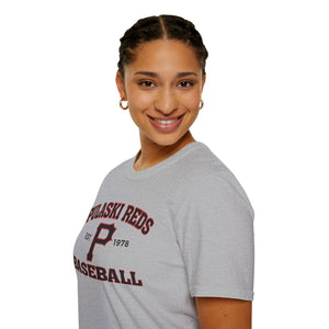 A woman with braided hair smiles, wearing the Printify "P Reds Baseball Est. 1978 - Unisex Softstyle T-Shirt Volume" and gold hoop earrings as she proudly poses against a white background.