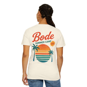 Wearing a Printify BODE Summer Camp T-Shirt 2026 — "Throwback Sunset," a unisex Comfort Colors 1717 tee with a back graphic of a sunset, palm trees, and waves.